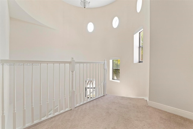 carpeted empty room featuring baseboards