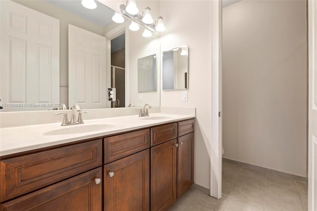 bathroom featuring a chandelier, tile patterned flooring, double vanity, and a sink