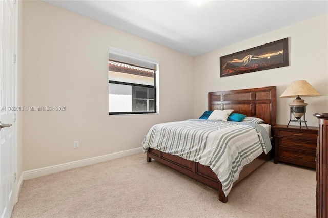 bedroom with light colored carpet and baseboards