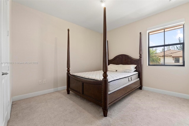 bedroom with baseboards and light carpet