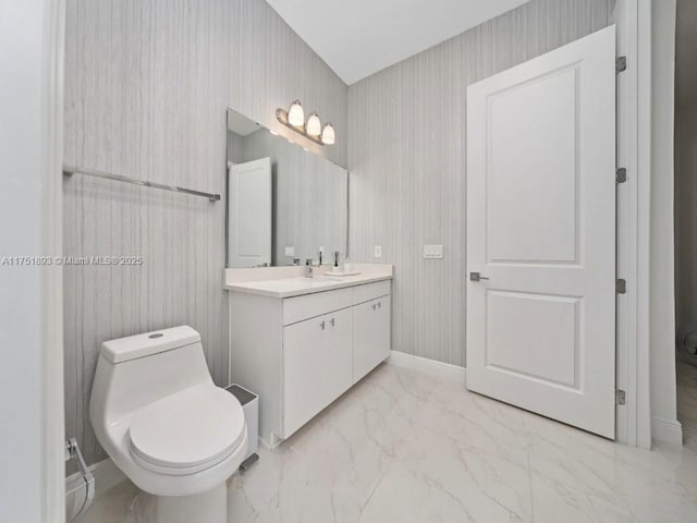 bathroom featuring vanity, toilet, baseboards, and marble finish floor