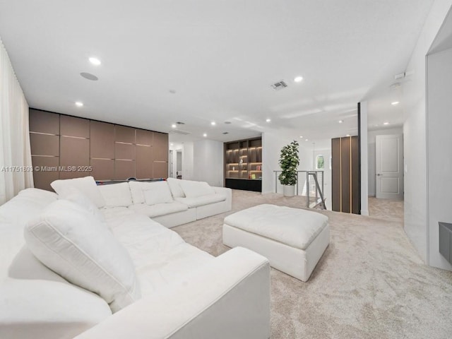 living area featuring recessed lighting, visible vents, and light carpet