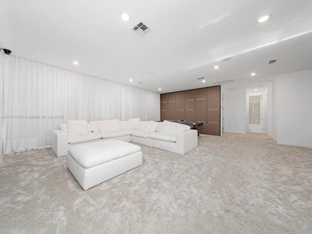 living area with recessed lighting, light colored carpet, and visible vents