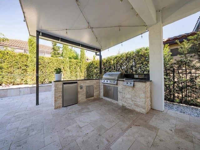 view of patio featuring area for grilling, a grill, and fence