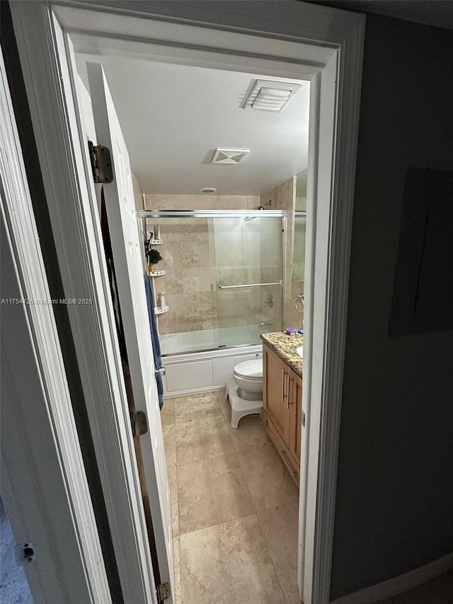 bathroom with visible vents, toilet, electric panel, shower / bath combination with glass door, and vanity