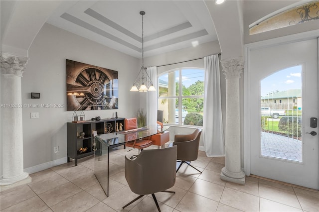 dining area featuring baseboards, ornate columns, an inviting chandelier, a tray ceiling, and light tile patterned flooring