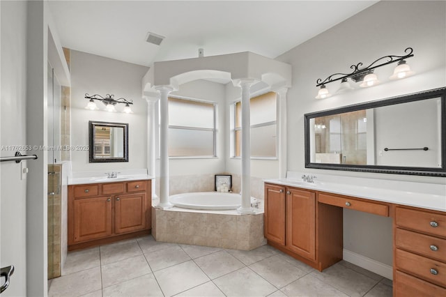 bathroom with a garden tub, two vanities, decorative columns, tile patterned floors, and a sink