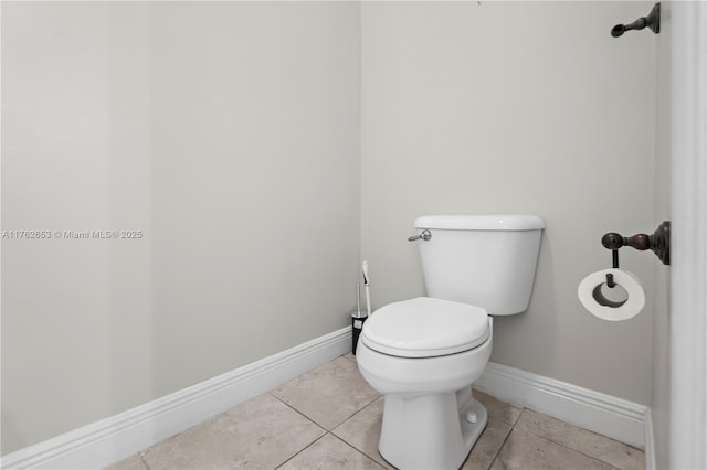 bathroom featuring tile patterned flooring, toilet, and baseboards