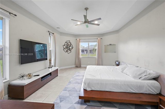 bedroom with a tray ceiling, light tile patterned floors, recessed lighting, and baseboards