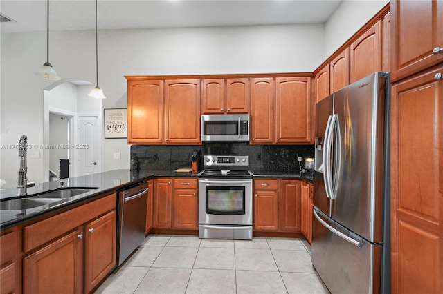 kitchen featuring a sink, decorative light fixtures, tasteful backsplash, and appliances with stainless steel finishes