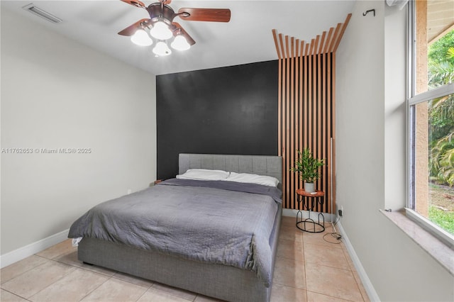 tiled bedroom featuring visible vents, a ceiling fan, and baseboards