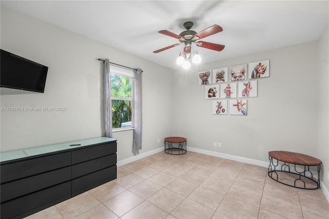 spare room featuring baseboards, light tile patterned flooring, and a ceiling fan