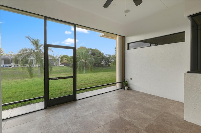 unfurnished sunroom featuring a ceiling fan