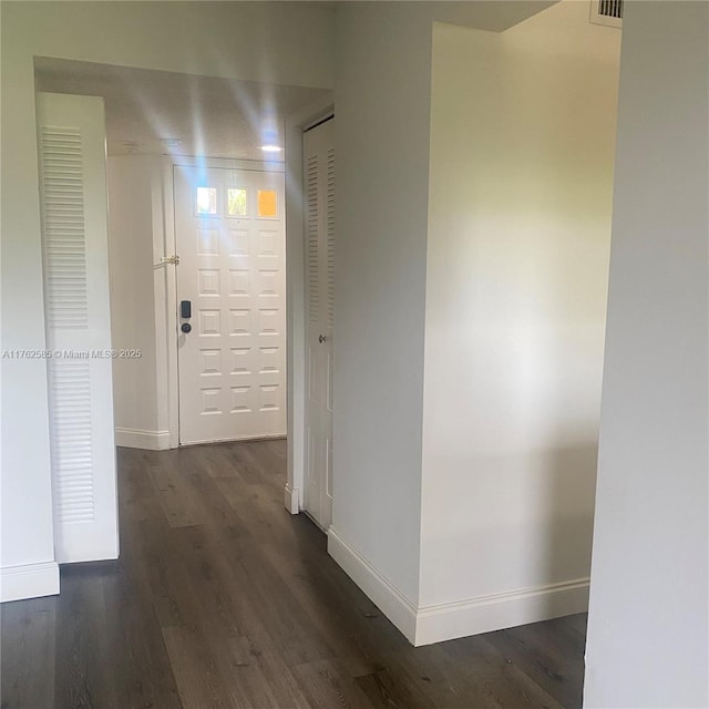 hall featuring baseboards and dark wood-style floors