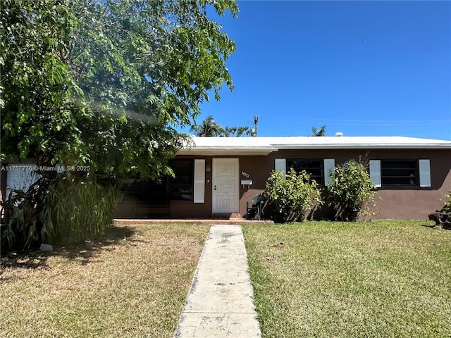 view of front facade featuring stucco siding and a front lawn