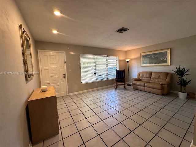 living room with light tile patterned flooring, visible vents, and baseboards