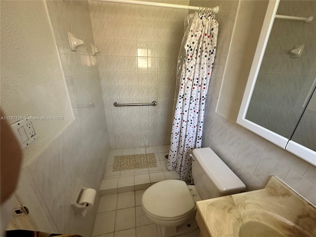 bathroom with vanity, tiled shower, tile walls, toilet, and tile patterned floors