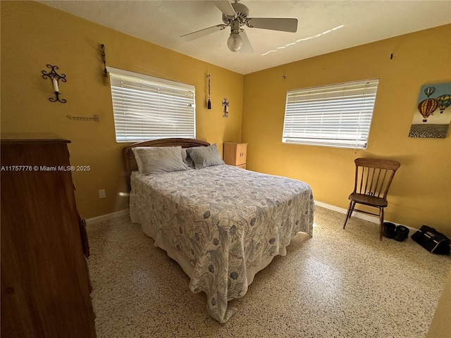 bedroom featuring light speckled floor, baseboards, and ceiling fan