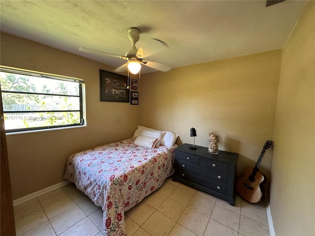 bedroom featuring light tile patterned flooring, a ceiling fan, and baseboards