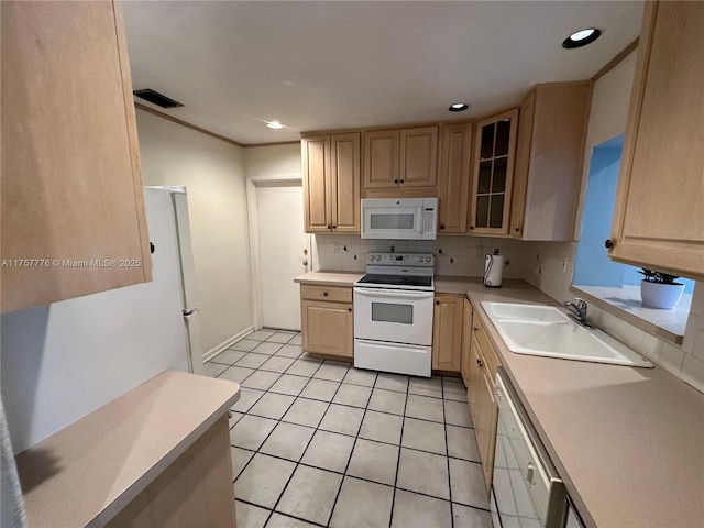 kitchen with light brown cabinets, a sink, white appliances, light countertops, and decorative backsplash