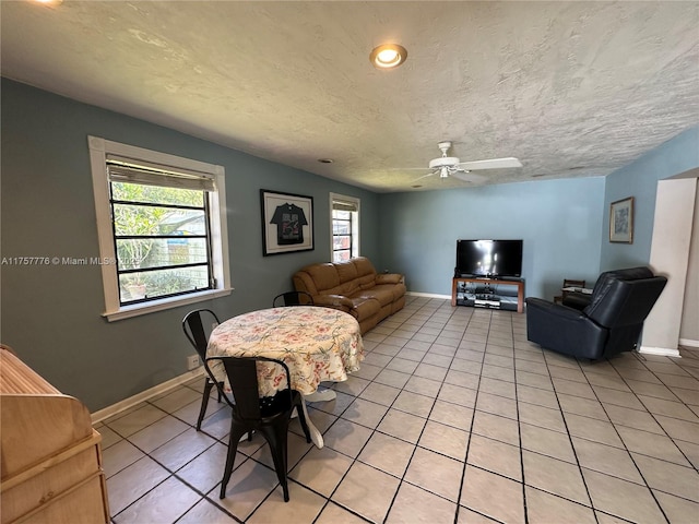 living area featuring light tile patterned floors, a healthy amount of sunlight, and a textured ceiling