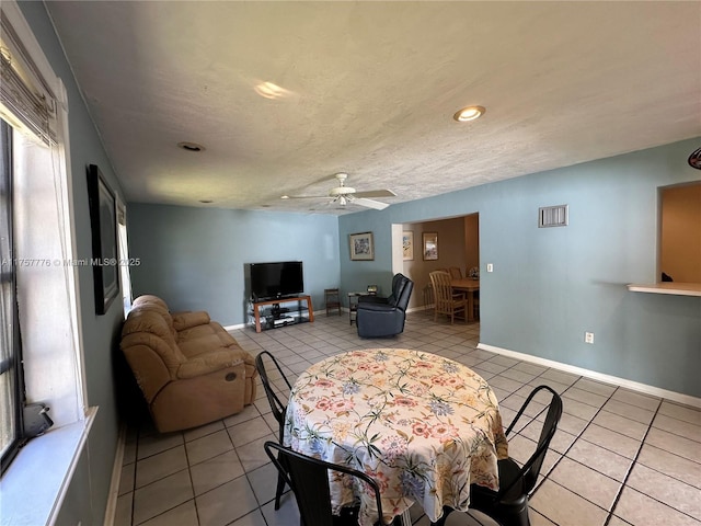 dining space featuring light tile patterned floors, visible vents, a ceiling fan, and baseboards