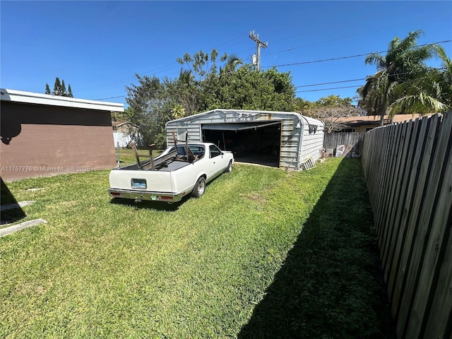 view of yard with fence private yard, a garage, and an outdoor structure