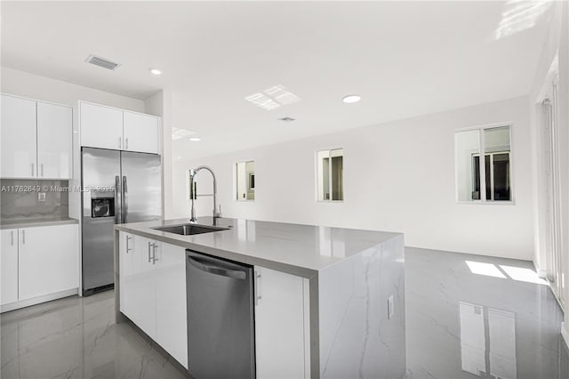 kitchen with modern cabinets, marble finish floor, appliances with stainless steel finishes, and a sink