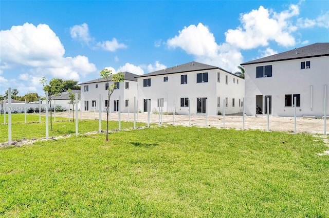 back of property featuring a yard, a patio, and stucco siding