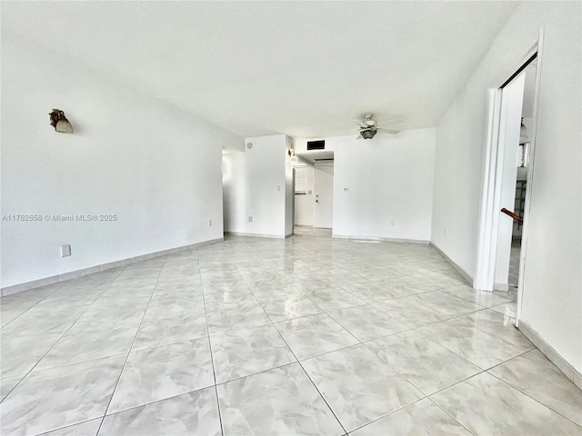 unfurnished room featuring light tile patterned floors, a ceiling fan, visible vents, and baseboards