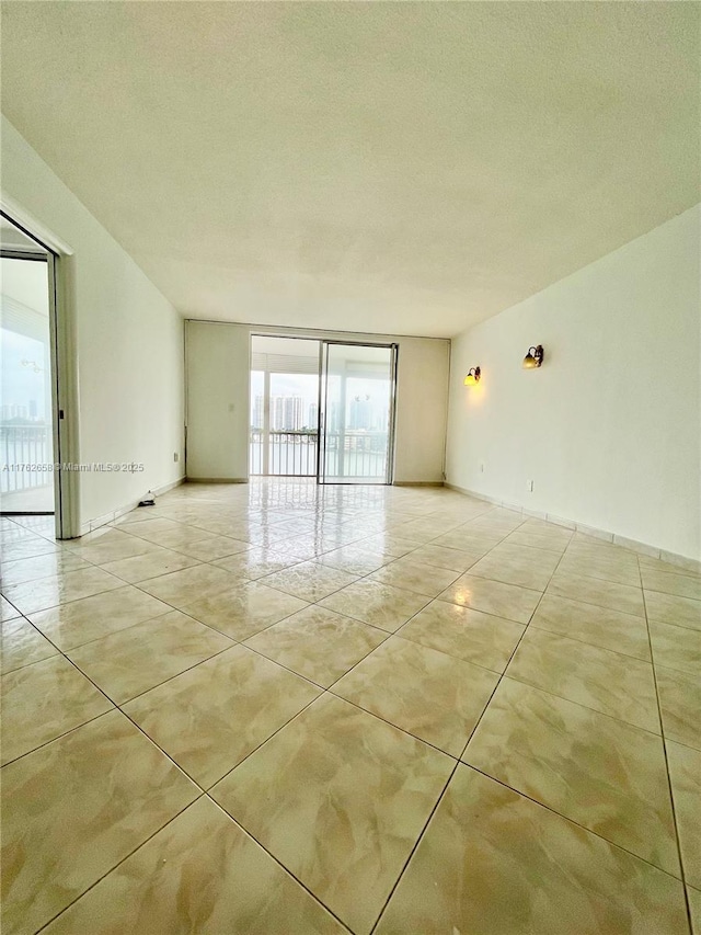 spare room featuring tile patterned flooring and a textured ceiling