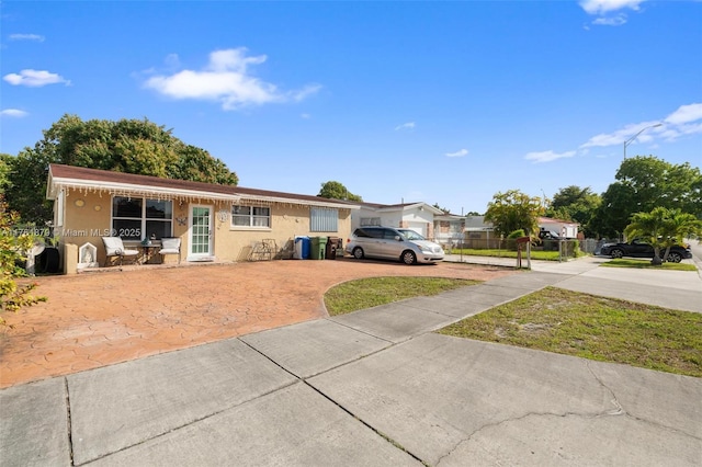 single story home featuring stucco siding and fence