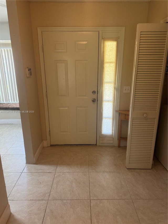 foyer featuring light tile patterned floors and baseboards