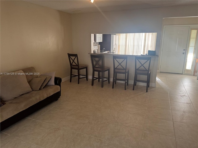 living area with light tile patterned floors and baseboards