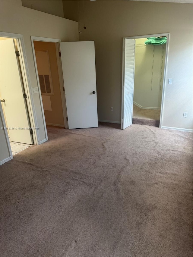 unfurnished bedroom featuring light colored carpet, baseboards, and connected bathroom