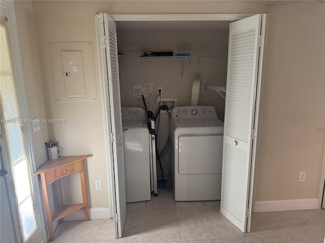 laundry room featuring electric panel, separate washer and dryer, light tile patterned flooring, baseboards, and laundry area