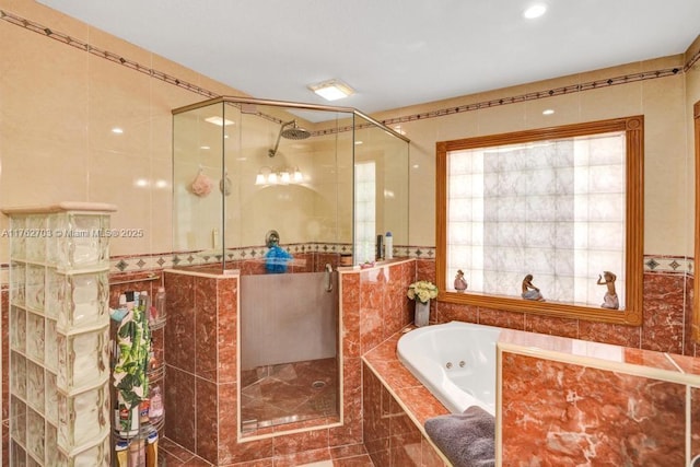 full bathroom featuring tile walls, a stall shower, and a whirlpool tub