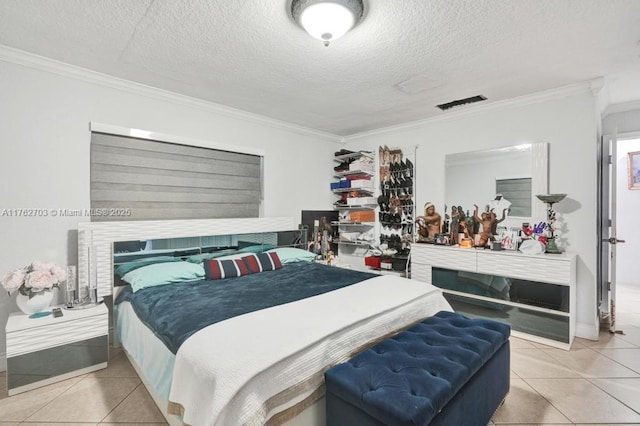 tiled bedroom featuring visible vents, a textured ceiling, ornamental molding, and a fireplace