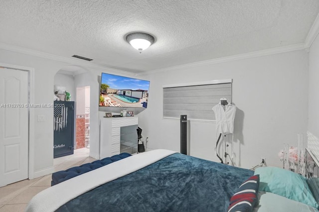 bedroom featuring visible vents, a fireplace, arched walkways, ornamental molding, and tile patterned floors