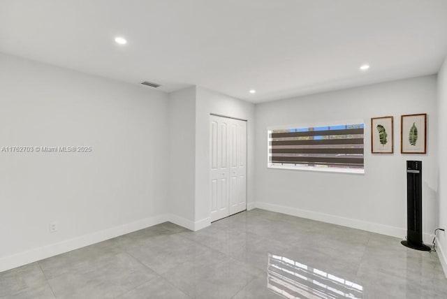 spare room with visible vents, recessed lighting, and baseboards