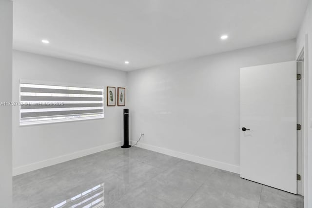 spare room with recessed lighting, baseboards, and concrete flooring