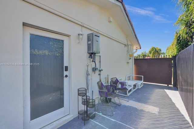 view of patio with water heater and fence