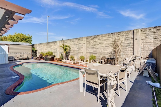 view of pool with a fenced in pool, outdoor dining area, an outdoor structure, a fenced backyard, and a patio area