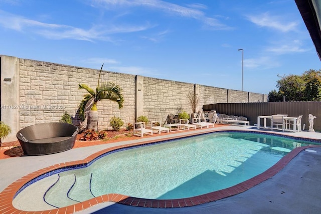 view of swimming pool with a fenced in pool, a fenced backyard, and a patio area