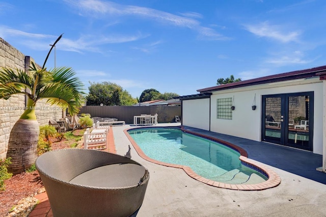 view of pool with a patio, a fenced backyard, a fenced in pool, and french doors