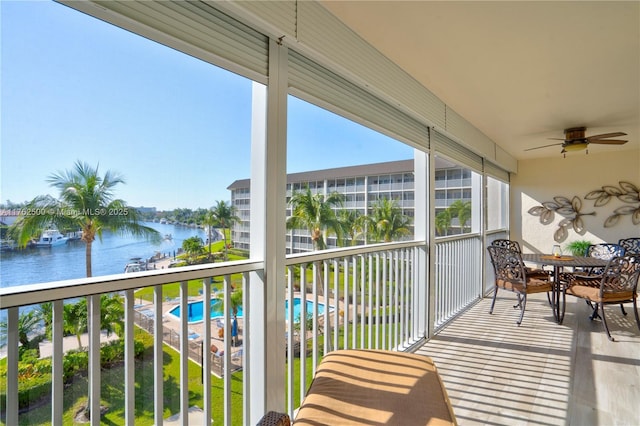 balcony featuring a water view and ceiling fan