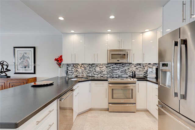 kitchen with a sink, dark countertops, stainless steel appliances, a peninsula, and white cabinets