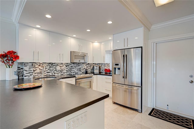 kitchen featuring a sink, dark countertops, appliances with stainless steel finishes, and ornamental molding