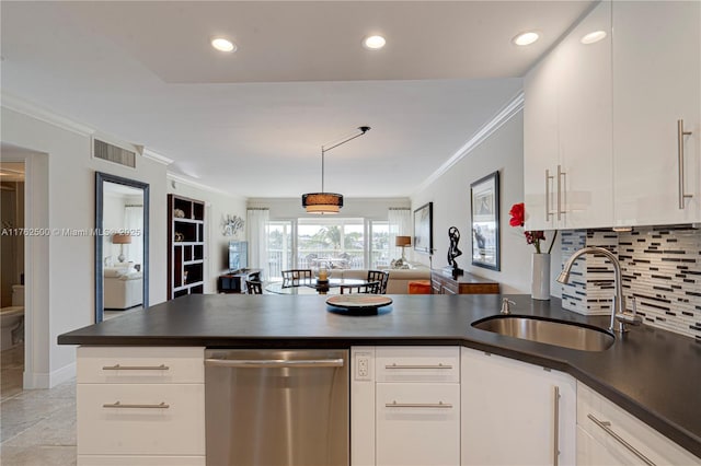 kitchen featuring visible vents, a sink, stainless steel dishwasher, dark countertops, and a peninsula