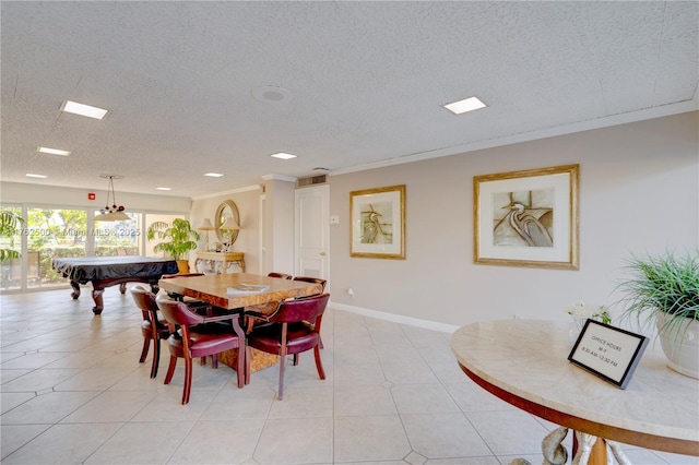 dining room with light tile patterned floors, a textured ceiling, crown molding, and baseboards